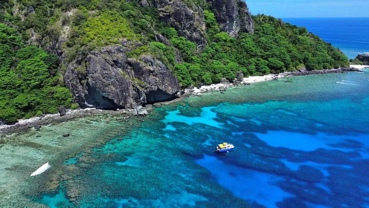 Boat anchored off the white sand of Monuriki on a Mamanuca Islands tour to the Cast Away filming location in Fiji